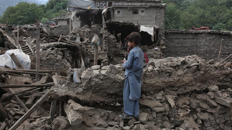 Ein Junge steht auf Trümmern im vom Erdbeben betroffenen Gebiet im Bezirk Nurgal in der Provinz Kunar in Afghanistan.