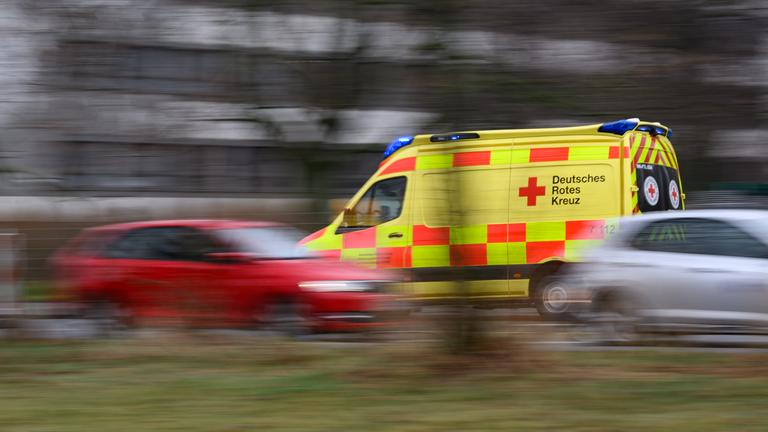 Eine Illustration eines Rettungswagens der schnell an zwei Autos vorbei fährt.