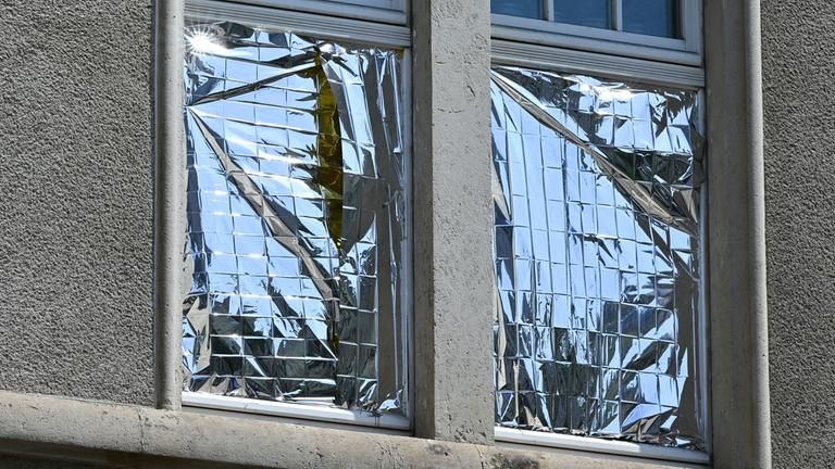 Sonnenstrahlen werden am Fenster eines Wohnhauses in Dresden von einer silberfarbenen Folie reflektiert.