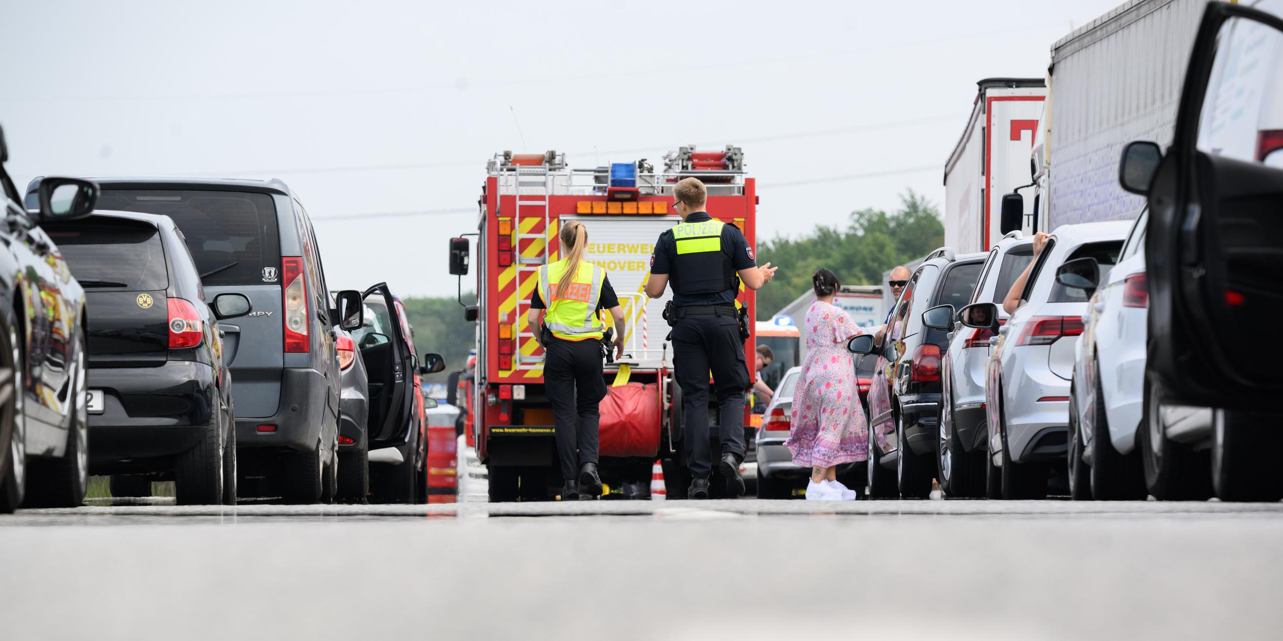Polizisten laufen nach einem Unfall durch die Rettungsgasse. 