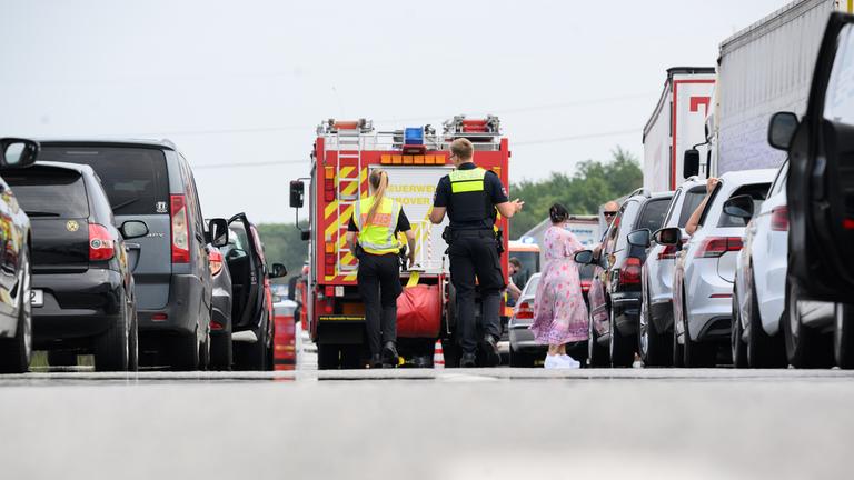 Polizisten laufen nach einem Unfall durch die Rettungsgasse. 