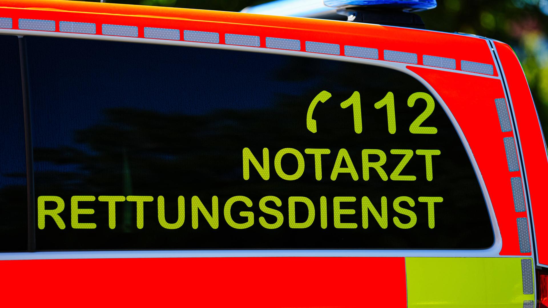 Ein Teil eines Rettungswagens mit Blaulicht und der Aufschrift 112, Rettungsdiesnst, Notarzt ist zu sehen.