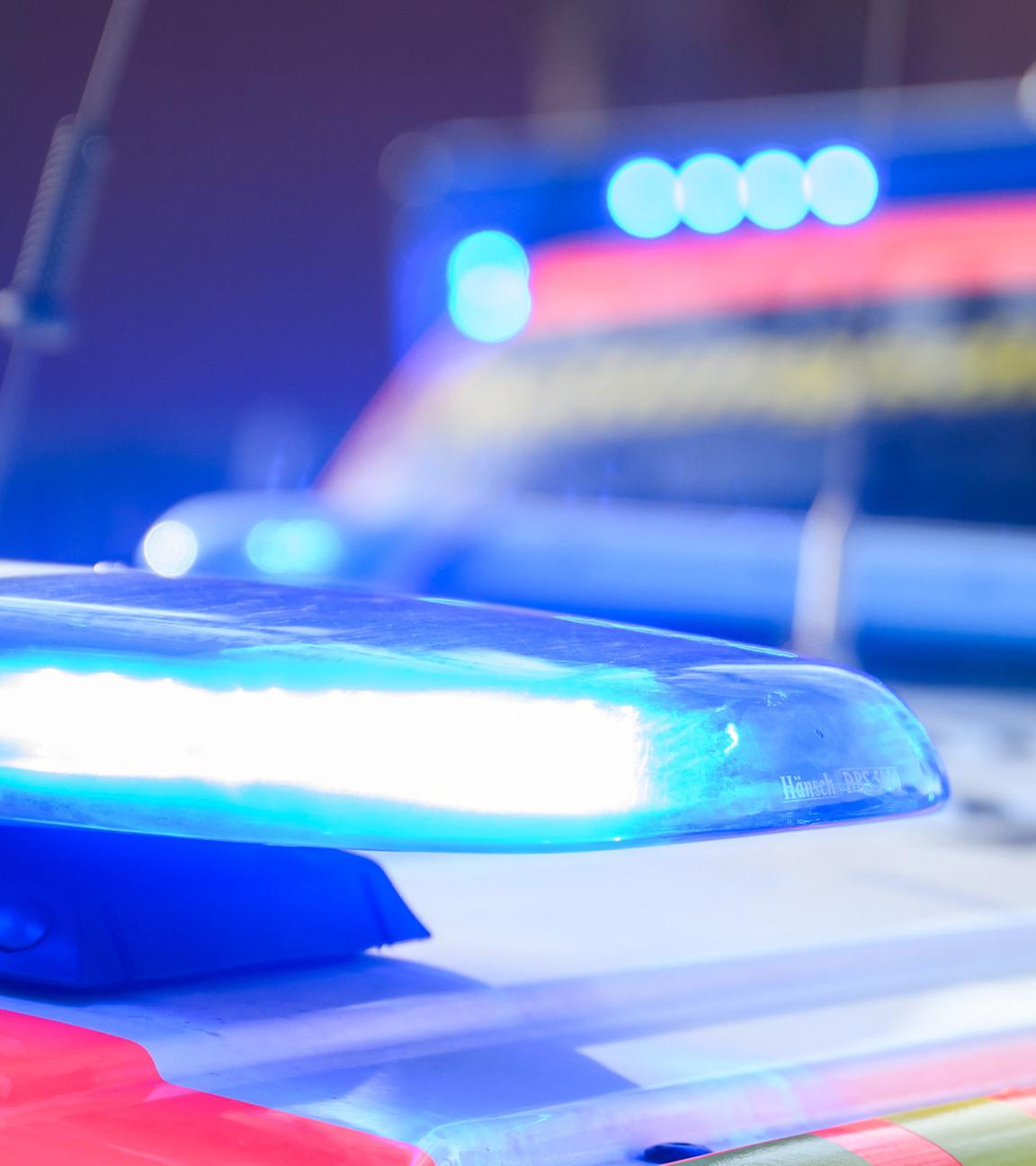  Blaulichter leuchten an einer Einsatzstelle auf einem Notarzt Fahrzeug und einem Rettungswagen (Symbolbild)