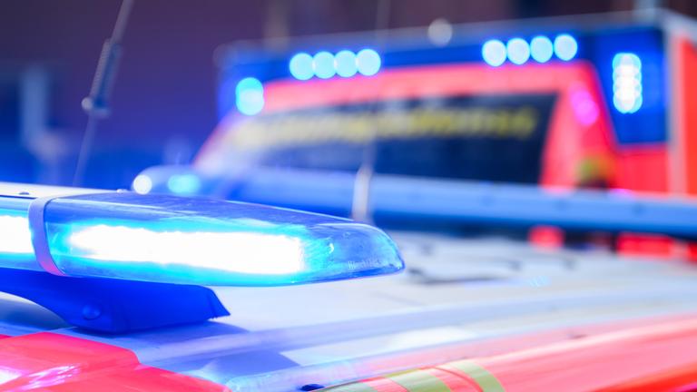  Blaulichter leuchten an einer Einsatzstelle auf einem Notarzt Fahrzeug und einem Rettungswagen (Symbolbild)