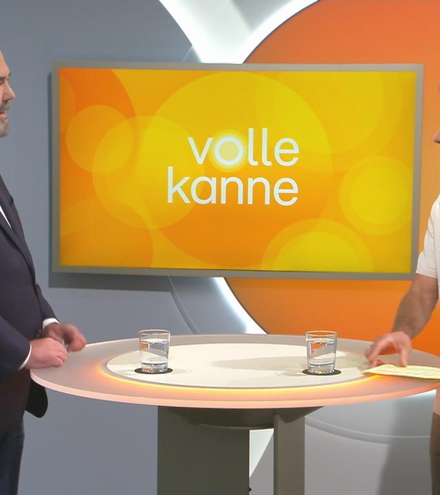 Thomas Ahlmann und Florian Weiss stehen sich an einem Pult gegenüber.