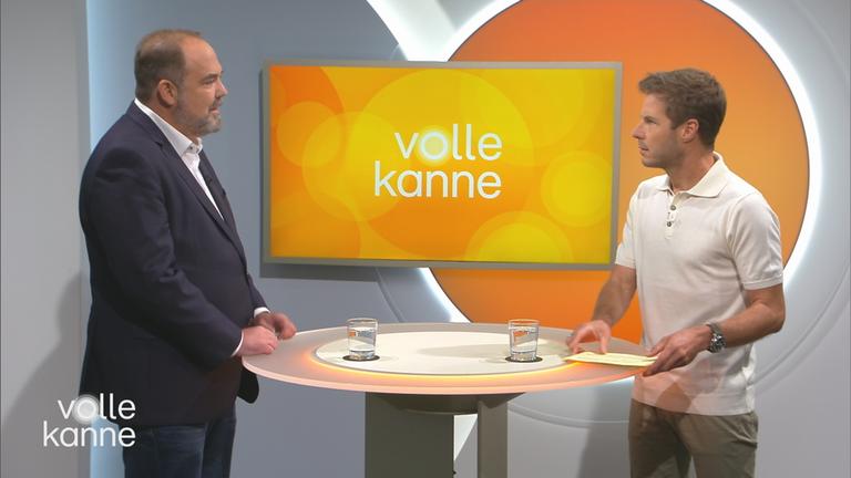 Thomas Ahlmann und Florian Weiss stehen sich an einem Pult gegenüber.