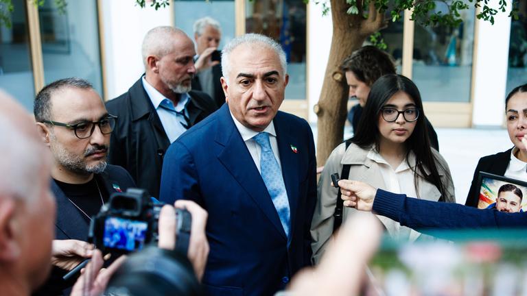 Reza Pahlavi (M.), im Exil lebender Sohn des letzten Schahs des Iran, spricht nach einer Pressekonferenz in der Bundespressekonferenz mit den Medien in Berlin, Deutschland, am 23. April 2026.