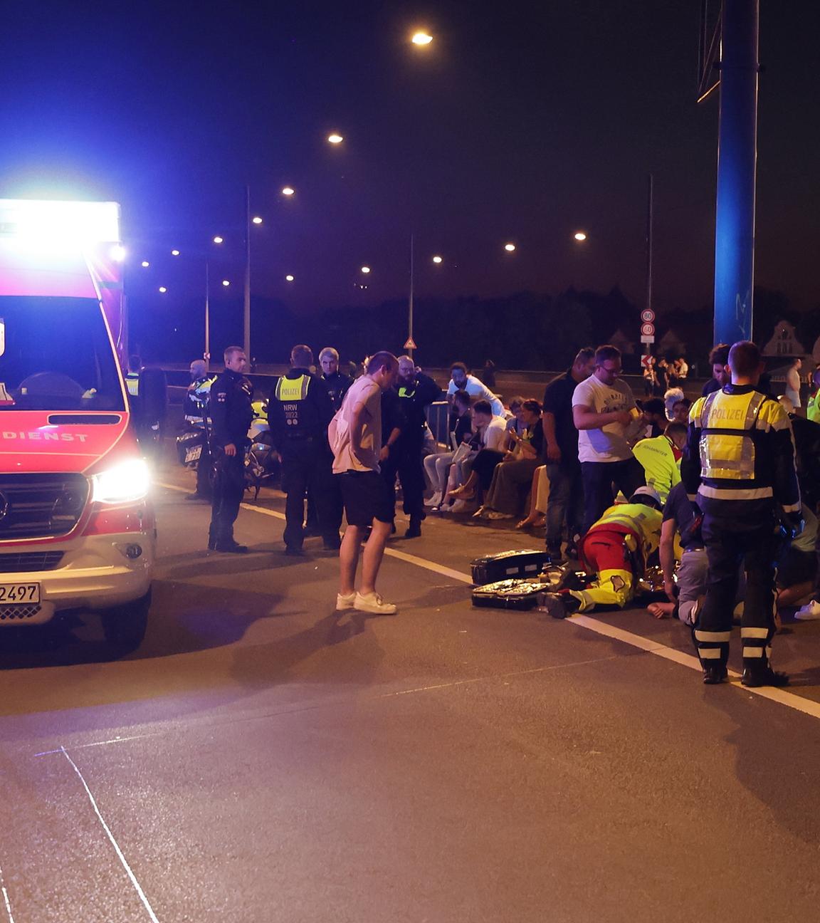 18.07.2025, Nordrhein-Westfalen, Düsseldorf: Rettungskräfte arbeiten an Verletzten auf einer Brücke.