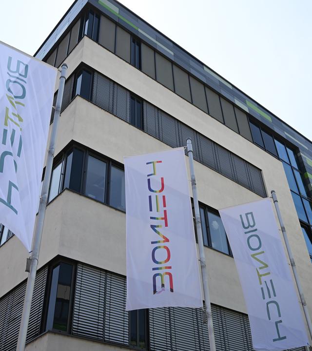 Rheinland-Pfalz, Mainz: Fahnen wehen vor dem Büro- und Laborgebäude des Pharmaunternehmens Biontech.