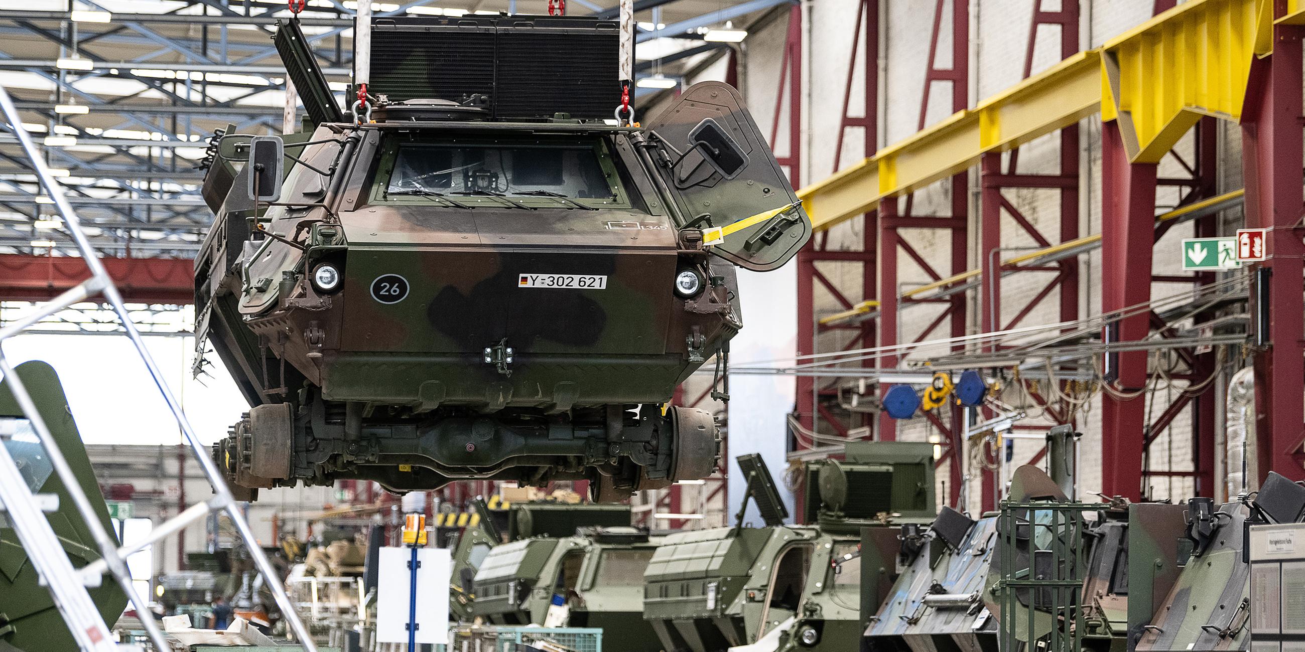 (Archiv) Ein Panzer vom Typ Fuchs schwebt in der Fertigungshalle von Rheinmetall.