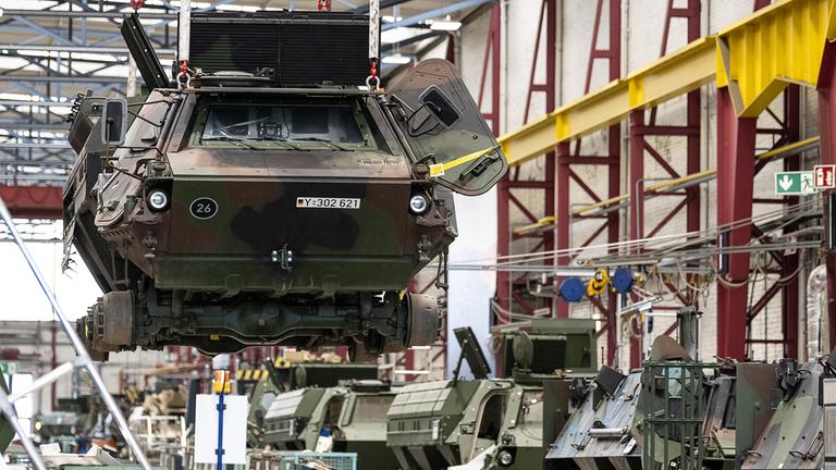 (Archiv) Ein Panzer vom Typ Fuchs schwebt in der Fertigungshalle von Rheinmetall.