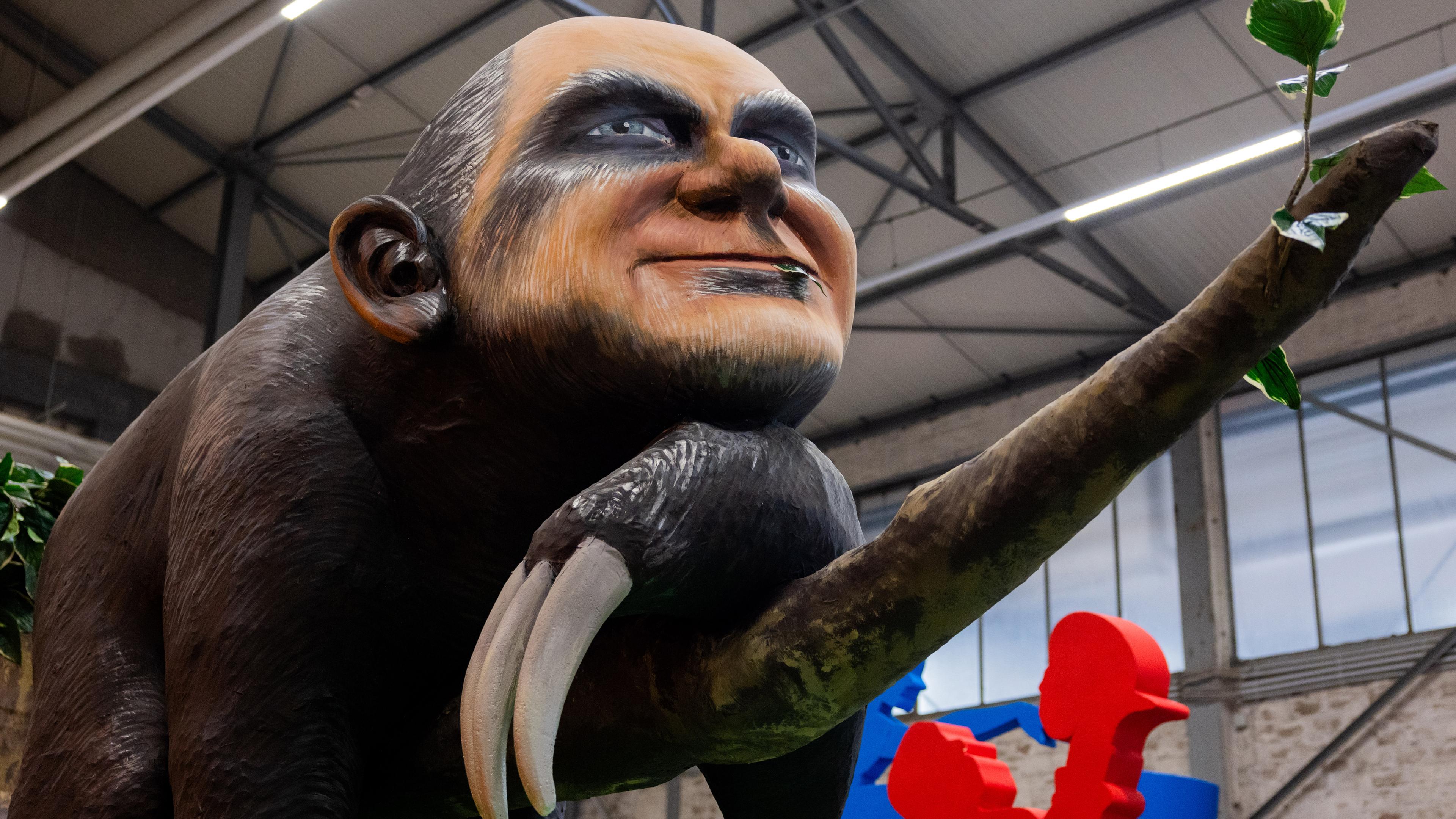 Ein Motivwagen, der Bundeskanzler Olaf Scholz als Faultier zeigen soll, steht beim Richtfest für den Kölner Rosenmontagszug im Karnevalsmuseum.