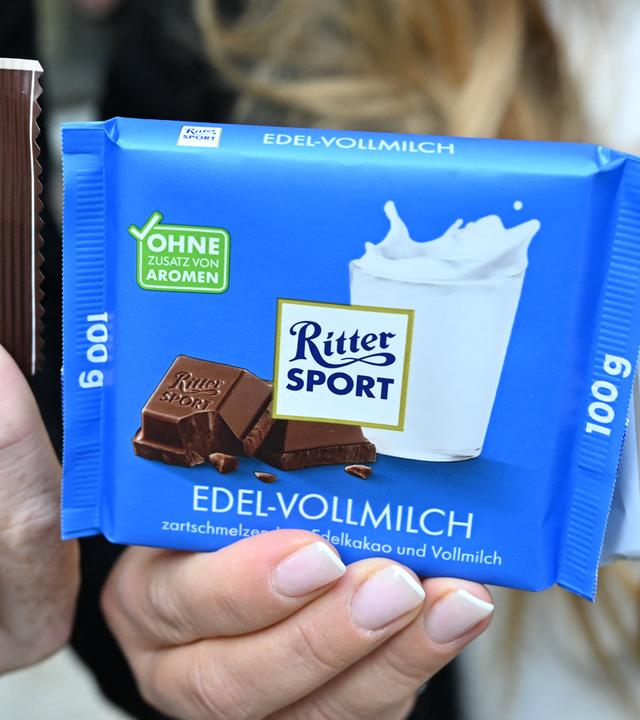  Matteo (l) und Melanie Wacker (r), die Betreiber der Firma Wacker, halten vor dem Oberlandesgericht Riegel der Firma Wacker und eine Ritter Sport Schokolade in den Händen. 