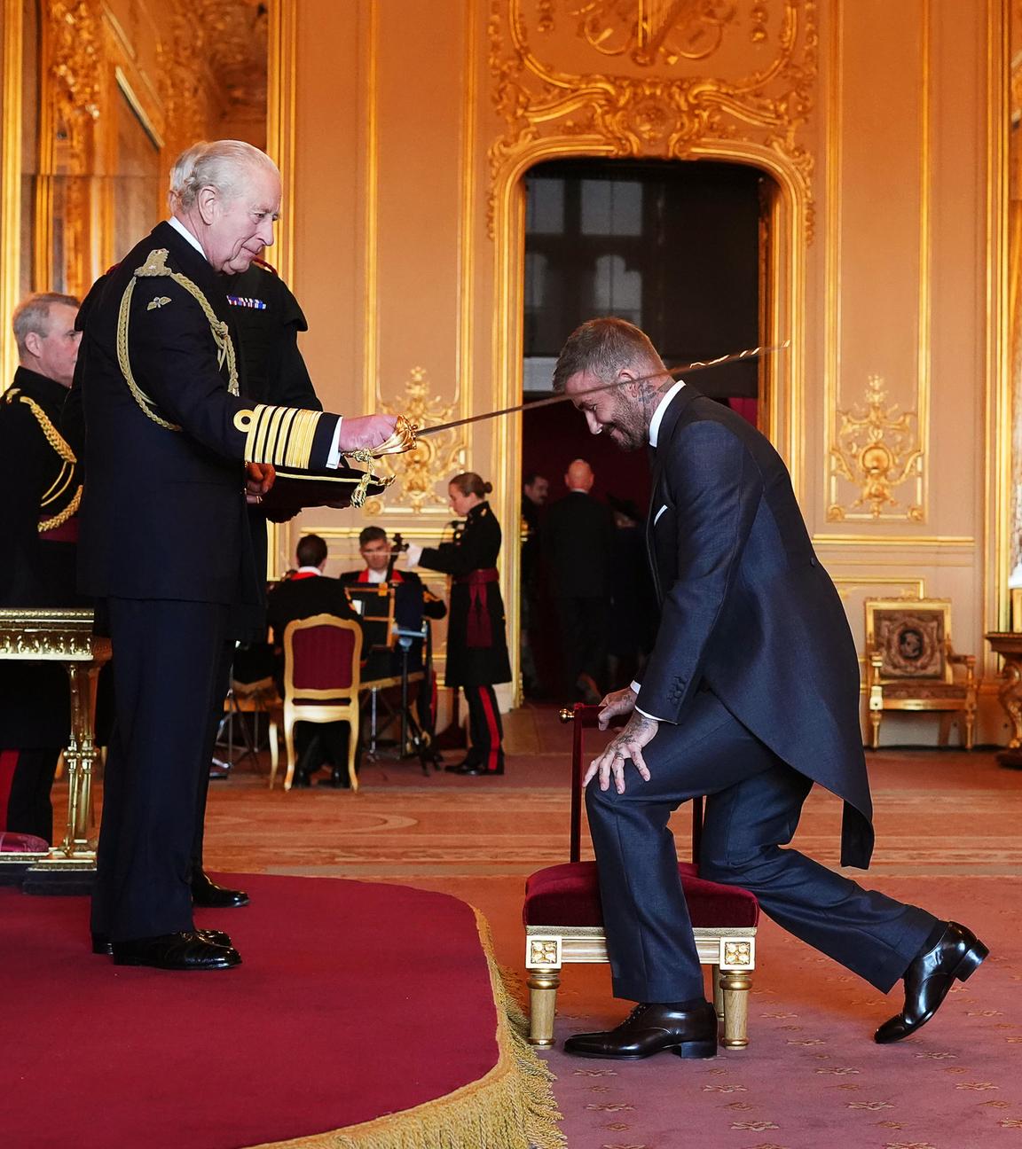 Sir David Beckham (Mitte) wird von König Charles III. (links) während einer Zeremonie auf Schloss Windsor in den Ritterstand erhoben.
