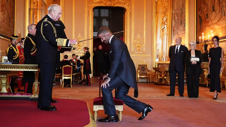 Sir David Beckham (Mitte) wird von König Charles III. (links) während einer Zeremonie auf Schloss Windsor in den Ritterstand erhoben.