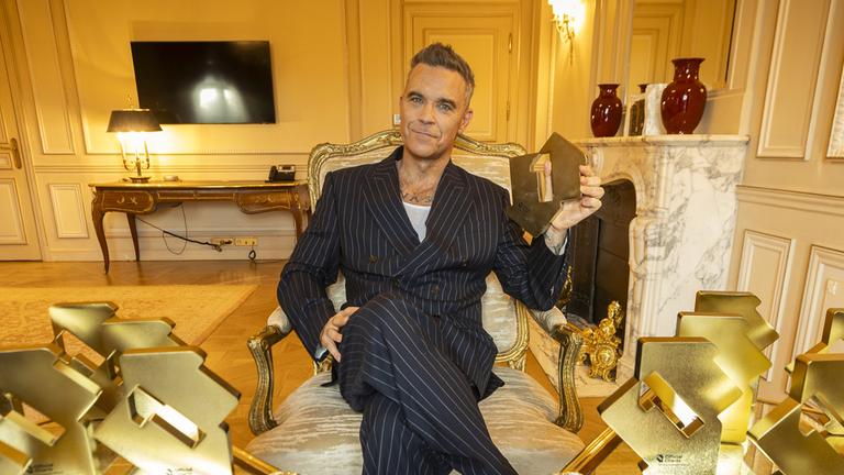  Robbie Williams mit seinen offiziellen Nummer-1-Album-Auszeichnungen der Official Charts.