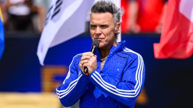 Sänger Robbie Williams performt auf einem Event.