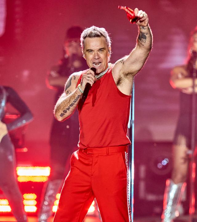 Sänger Robbie Williams auf der Bühne bei einem Konzert.