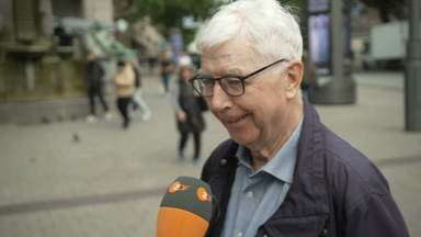 Robert Bleder spricht lächelnd in ein Mikrofon des ZDF, das ihm hingehalten wird.