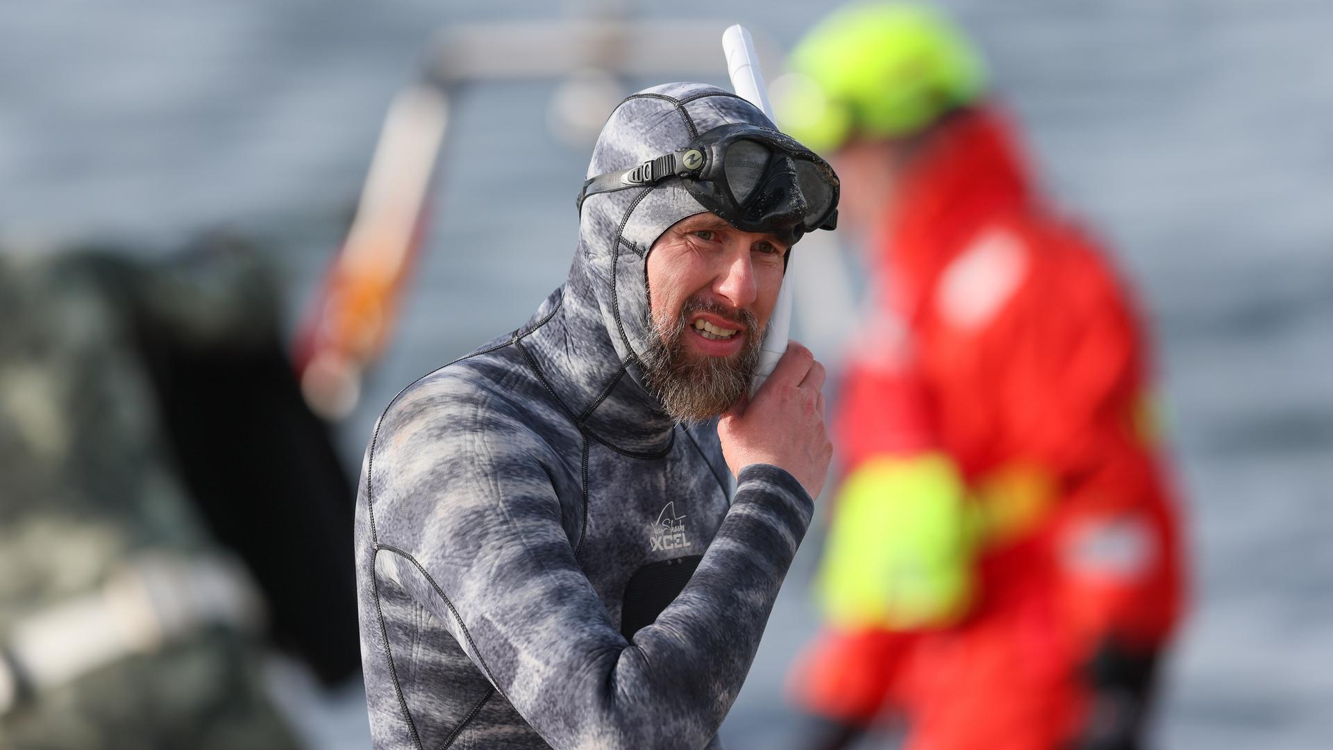 Der Meeresbiologe Robert Marc Lehmann bereitet sich am 26.03.2026 auf einen Tauchgang zu einem gestrandeten Wal vor, der in den Gewässern der Ostsee nahe dem Hafen von Niendorf in Timmendorfer Strand liegt. 