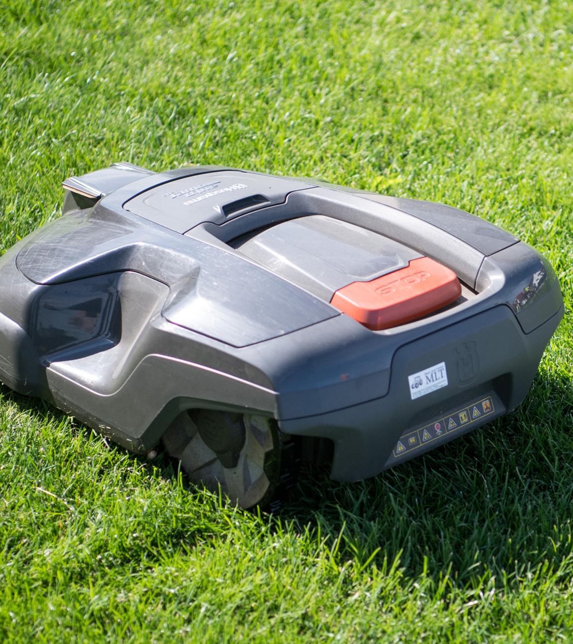 (Archiv) Ein Rasenmähroboter fährt über eine Wiese.