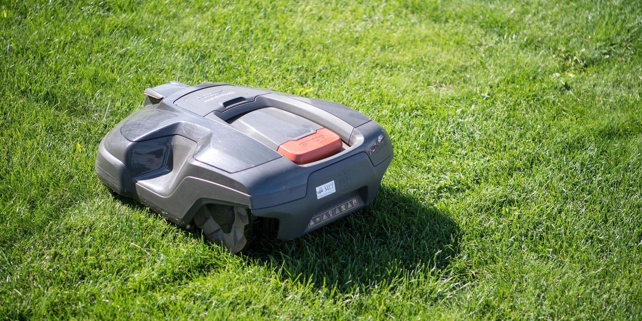 (Archiv) Ein Rasenmähroboter fährt über eine Wiese.