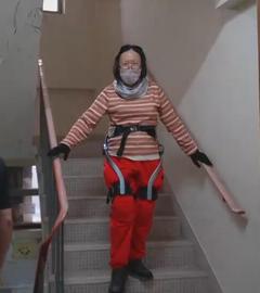 Frau bei Nutzung von Roboter-Anzug zum Treppensteigen in Hongkong.