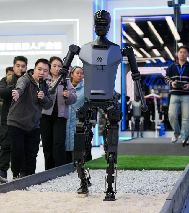 People visit a "Tiangong" humanoid robot at the Beijng World of Robots in Beijing
