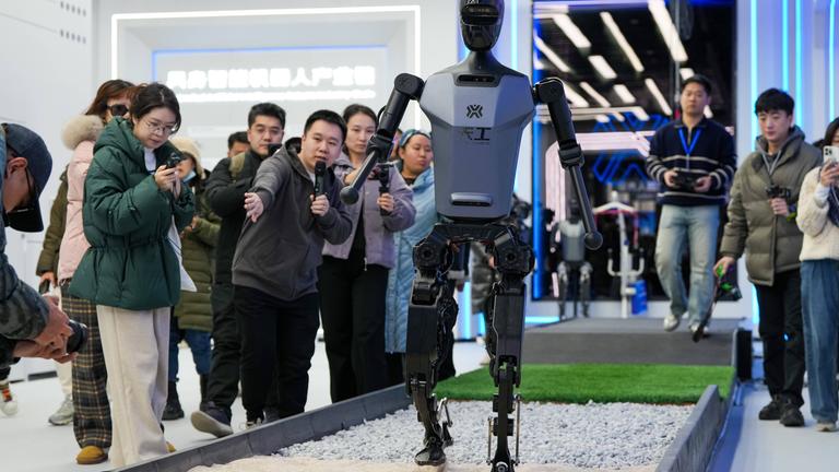 People visit a "Tiangong" humanoid robot at the Beijng World of Robots in Beijing