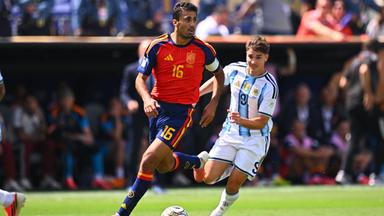 Der ballführende spanische Nationalspieler Rodri wird von seinem argentinischen Gegenspieler Julian Alvarez von hinten bedrängt