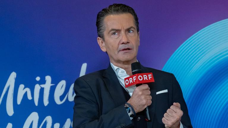 Roland Weißm,ann mit ernstem Blick und einem ORF-Mikrofon in der Hand.