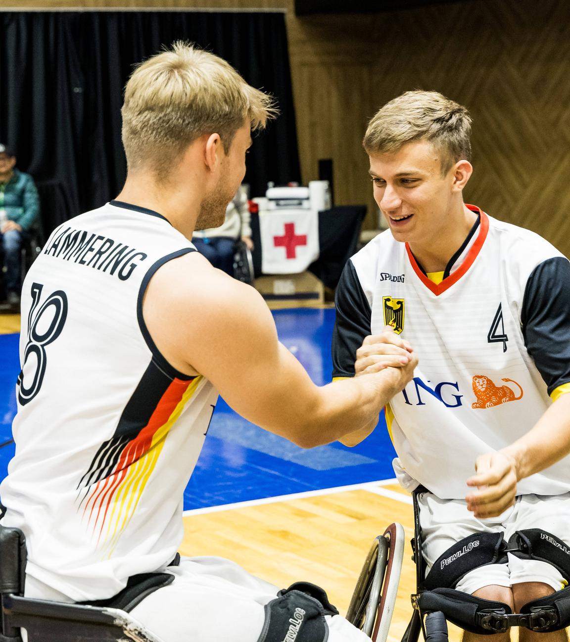 Die deutschen Rollstuhlbaketballer und Brüder Julian Lammering (Trikotnummer 18) und Maximilian Lammering klatschen sich ab.