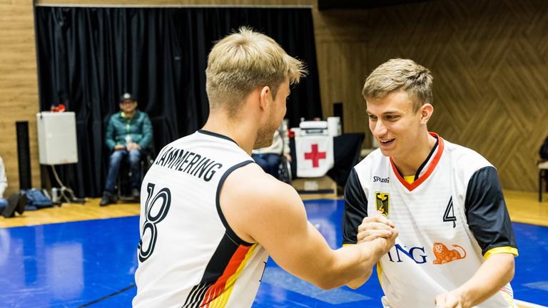 Die deutschen Rollstuhlbaketballer und Brüder Julian Lammering (Trikotnummer 18) und Maximilian Lammering klatschen sich ab.
