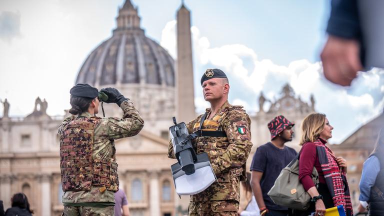 Soldaten stehen mit einer Drohnenabwehr-Waffe und Fernglas zum Schutz am Petersplatz. 