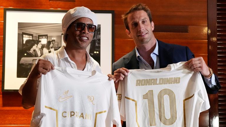 Ronaldinho hält das weiße trikot seines neuen Klubs hoch.
