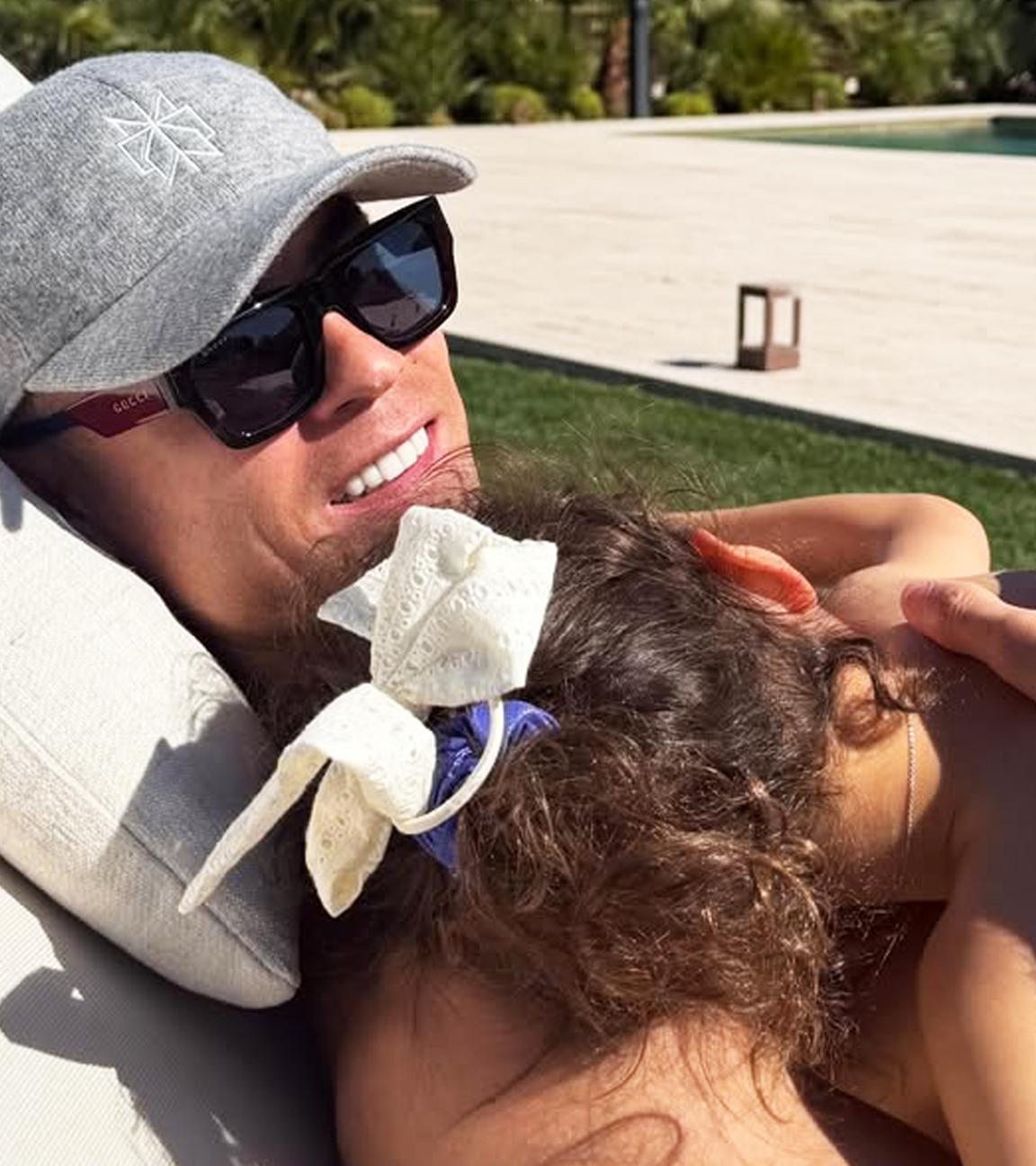 Fußballer Ronaldo liegt auf einer Sonnenliege mit seiner Tochter auf dem Bauch.