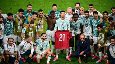 Cristiano Ronaldo hält ein Trikot mit der Nummer "21" in der Hand.
