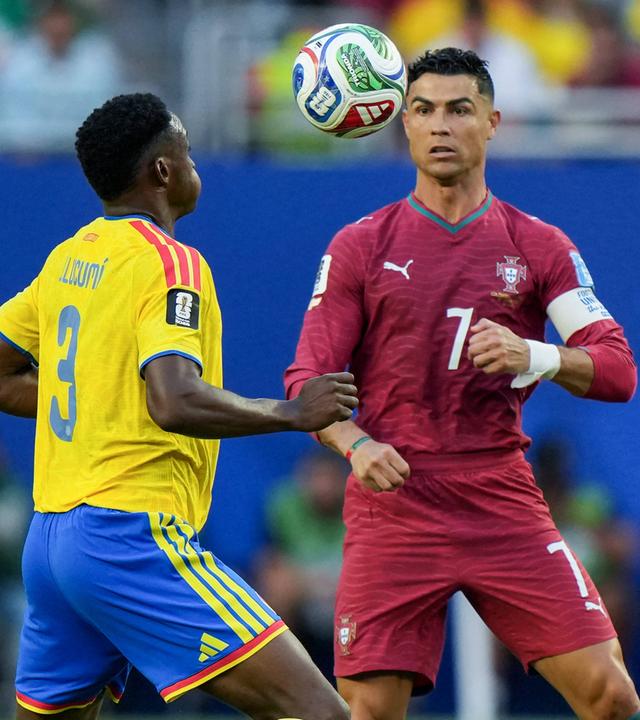 Der kolumbianische Nationalspieler Jhon Lucumi geht engagiert vor seinem portugiesischen Kontrahenten Christiano Ronaldo zum Ball