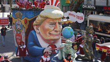 Nordrhein-Westfalen, Köln: Ein Motivwagen zum Thema Trump ("Amour fou - Donald Trumps Freak Show USA") fährt im Zug.