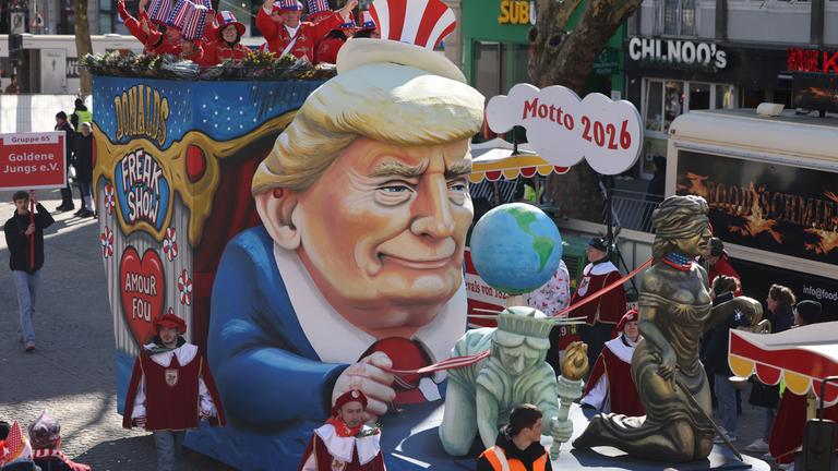 Nordrhein-Westfalen, Köln: Ein Motivwagen zum Thema Trump ("Amour fou - Donald Trumps Freak Show USA") fährt im Zug.