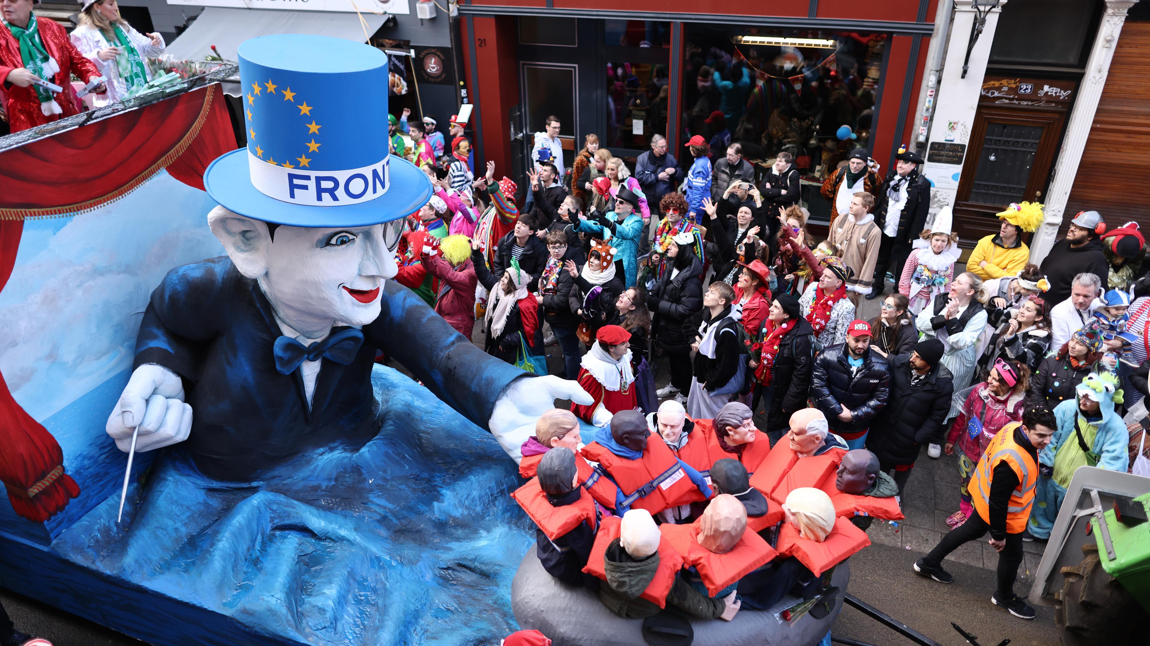Ein Motivwagen Frontex und Bootflüchtlinge fährt im Rosenmontagsumzug mit.