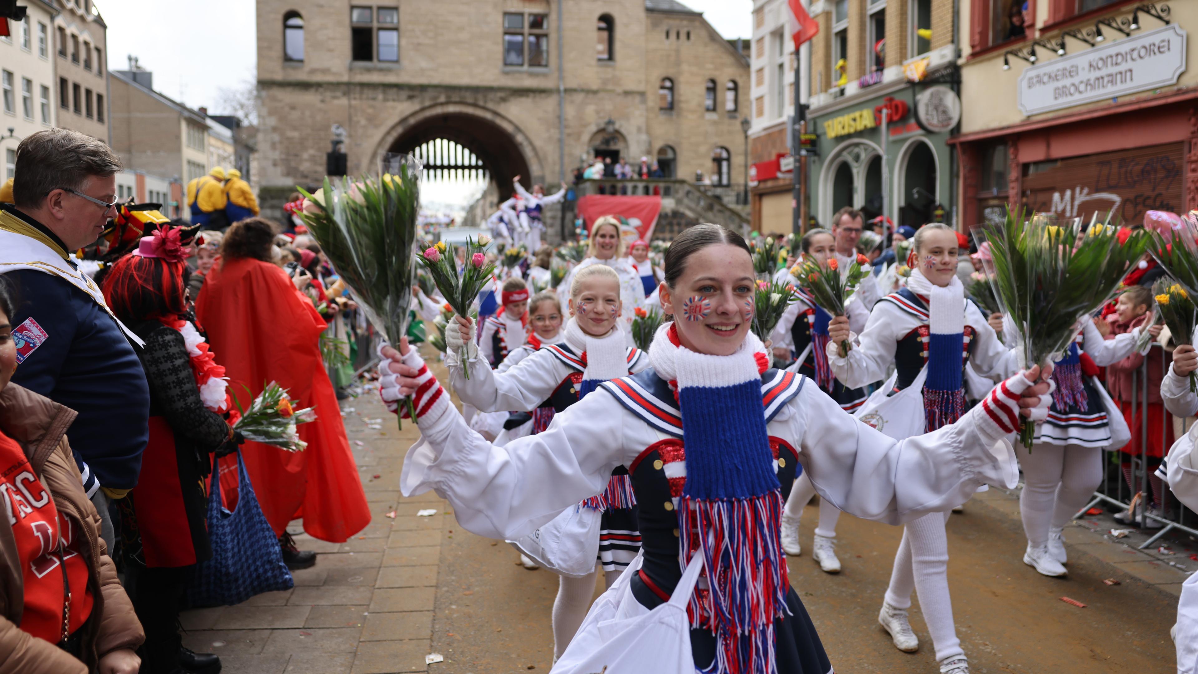 Nordrhein-Westfalen, Köln: Karnevalisten laufen im Rosenmontagsumzug mit.