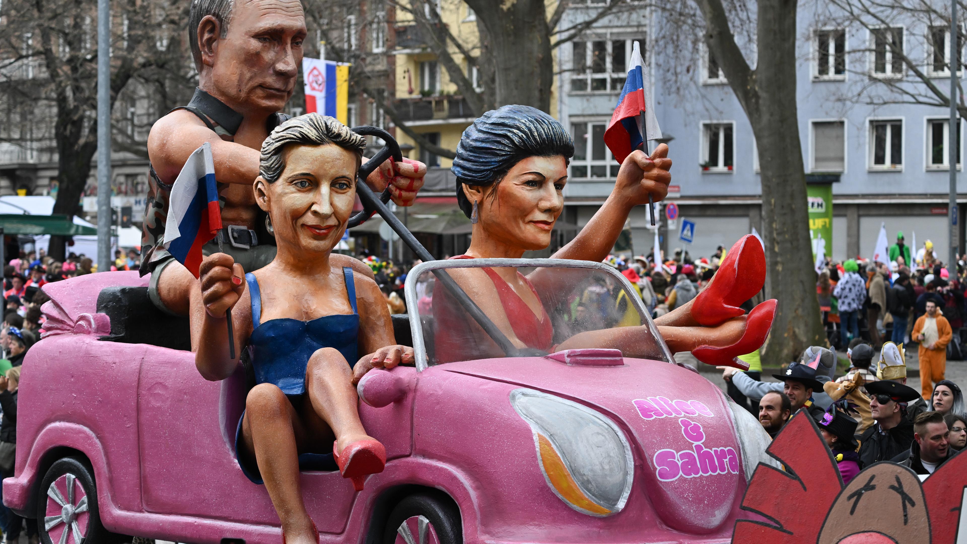 Auf einem Fastnachtsmotivwagen beim Rosenmontagsumzug in Mainz ist der russische Präsident Wladimir Putin sowie die deutschen Politikerinnen Sahra Wagenknecht und Alice Weidel zu sehen.