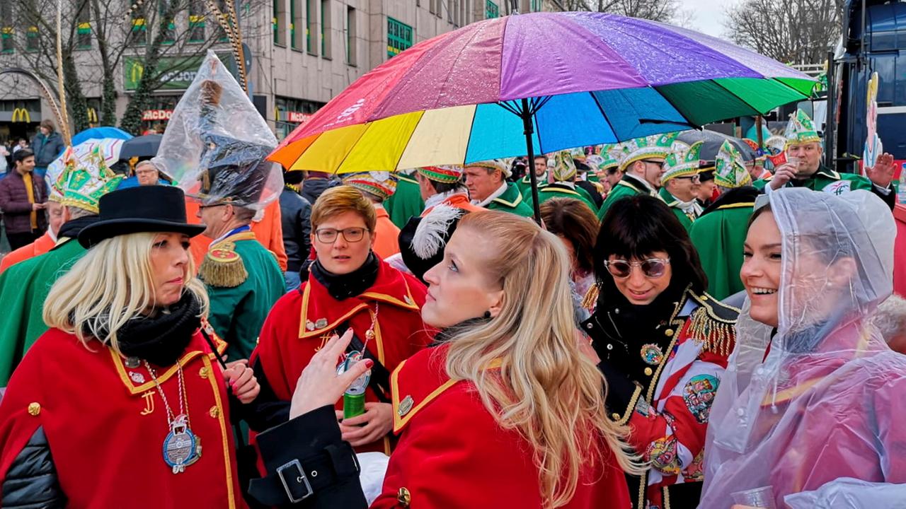Teilnehmer stehen nach der Absage des Rosenmontagszugs in Fulda zusammen