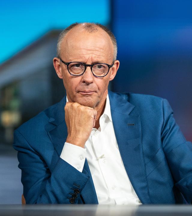 Berlin: Bundeskanzler Friedrich Merz (CDU) hört nach der RTL-Sendung "Am Tisch mit Friedrich Merz" einem Studiogast zu.