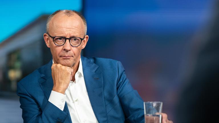 Berlin: Bundeskanzler Friedrich Merz (CDU) hört nach der RTL-Sendung "Am Tisch mit Friedrich Merz" einem Studiogast zu.