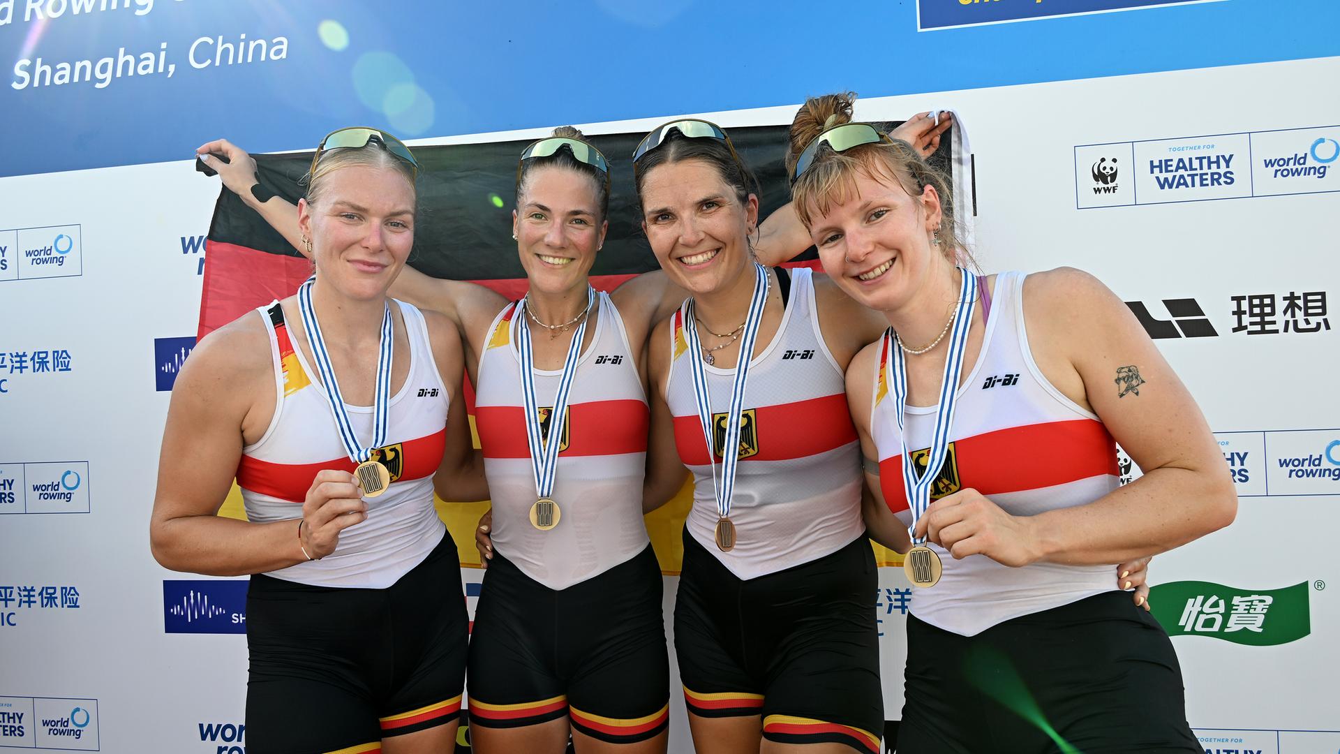 Der Frauen-Doppelvierer bejubelt bei der Siegerehrung WM-Bronze