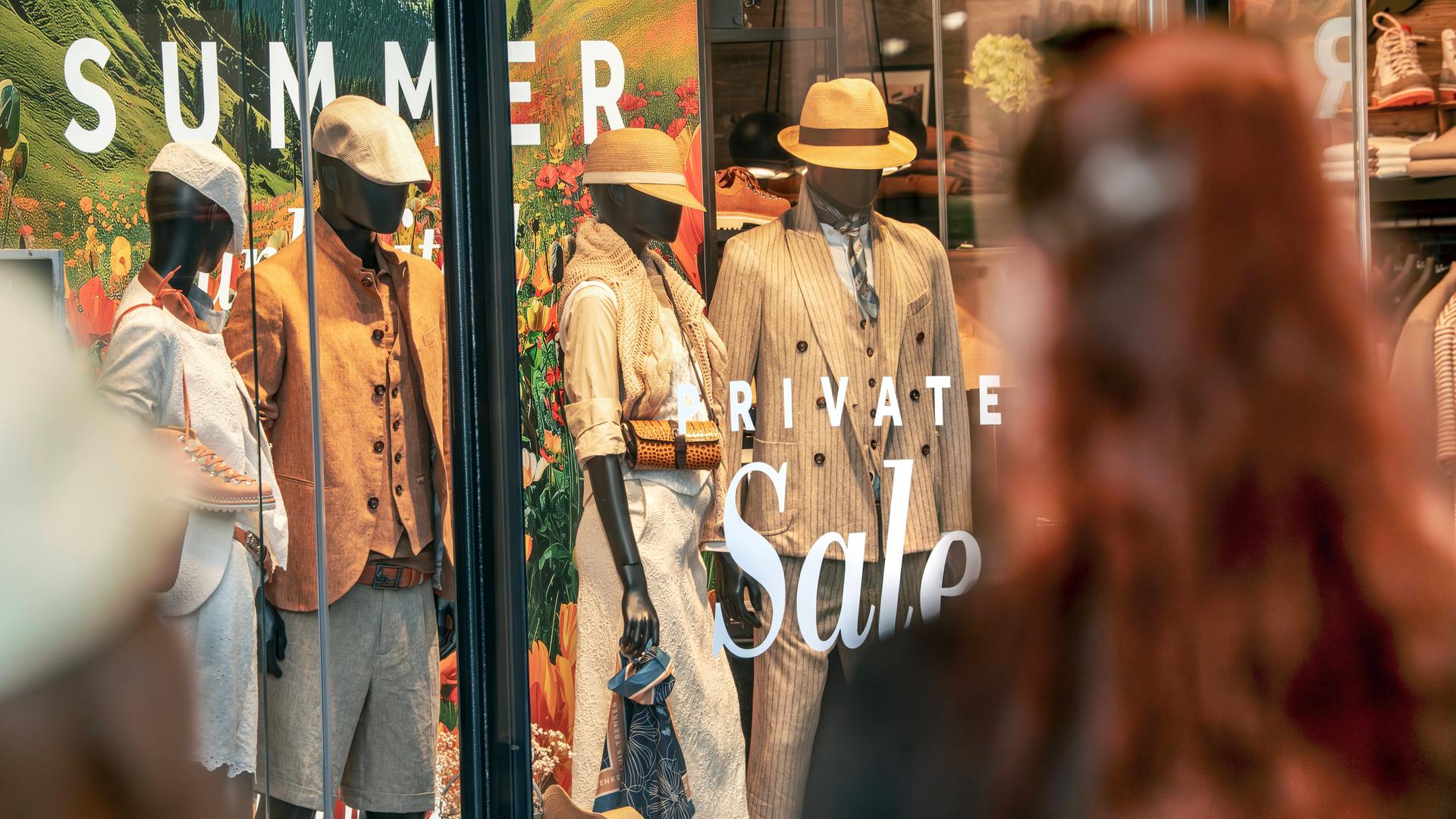 Zwei Frauen stehen im Juni 2025 vor einem Modegeschäft und betrachten das Schaufenster in der Theatinerstraße in München. 