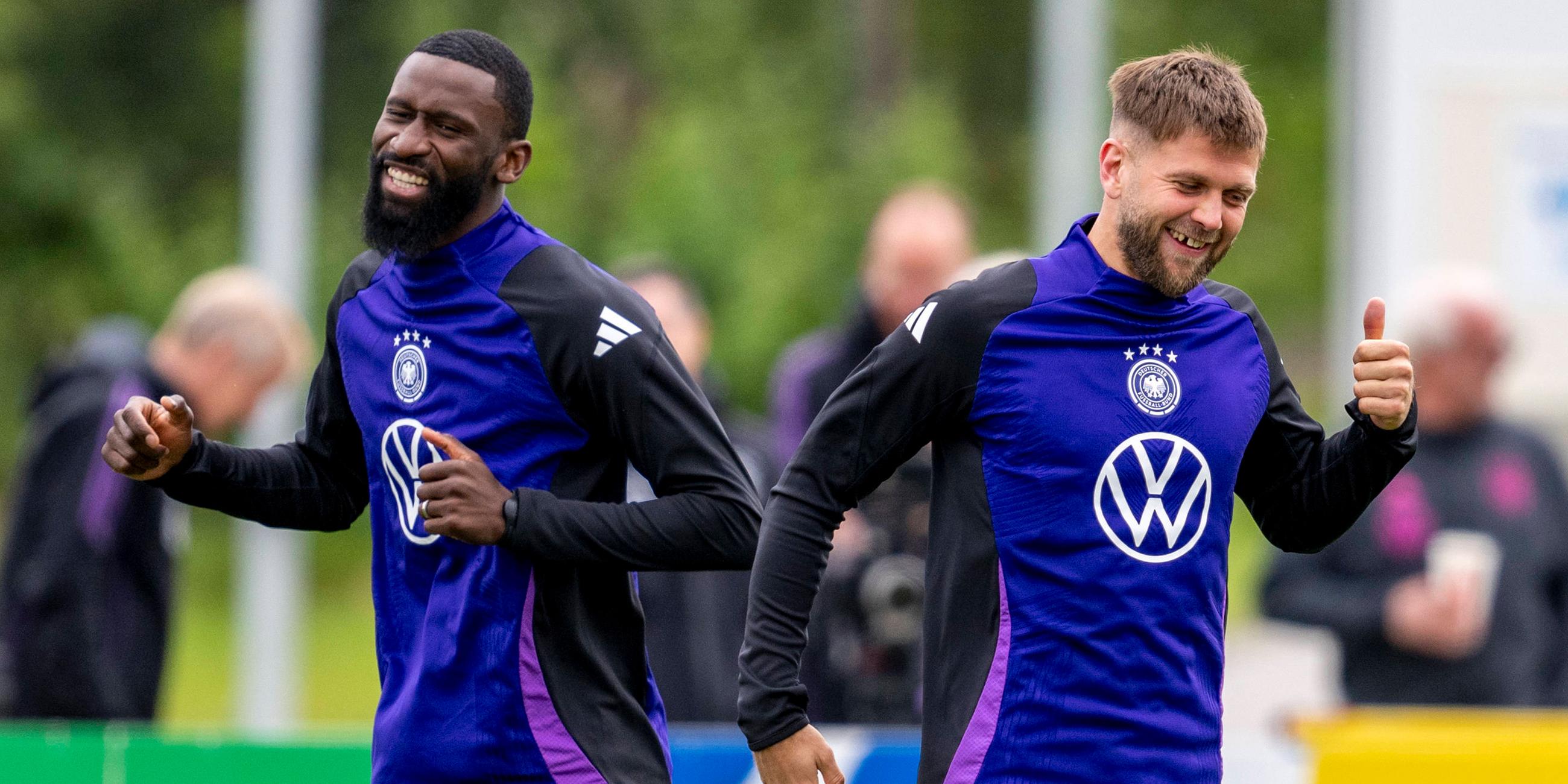 Antonio Rüdiger (l.) und Deutschlands Niclas Füllkrug lachen gemeinsam. 