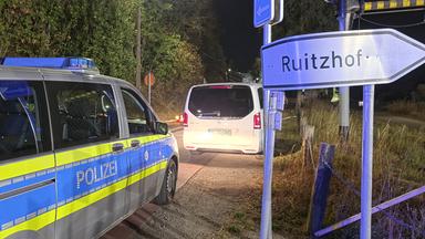 Ein Polizeifahrzeug steht im Rahmen von Evakuierungsarbeiten an einem Staßenschild mit der Aufschrift "Ruitzhof".